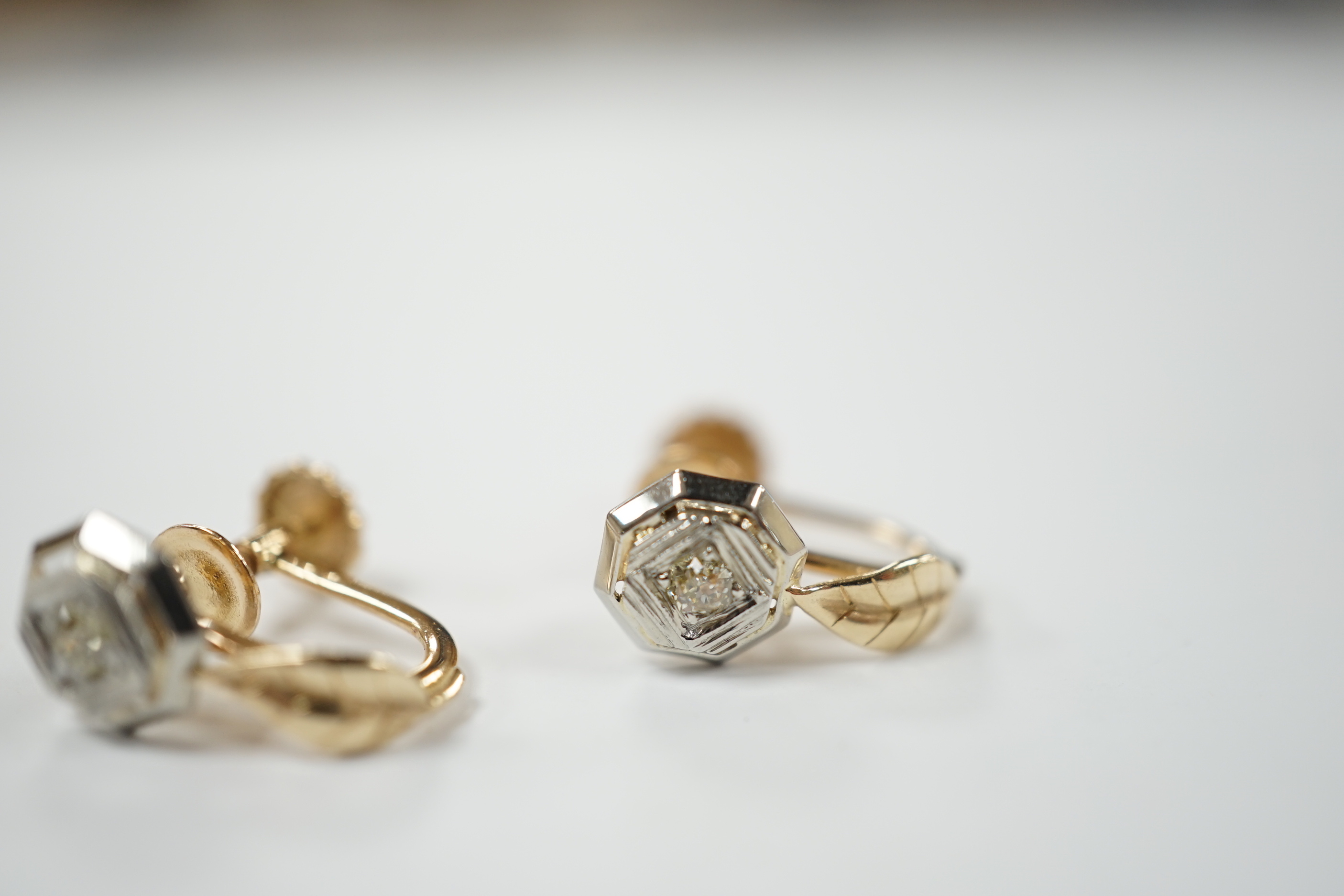 A pair of 14k gold and brilliant cut diamond earrings